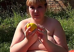 Overweldigende molliger in de tuin, duwt een citroen uit een dikke behaard kut